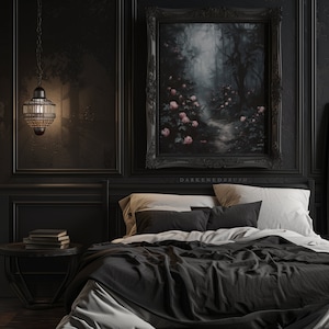 May include: A black bedroom with a large framed painting of a foggy forest path with pink flowers. The bed has black bedding and white pillows. A small table with books sits next to the bed.