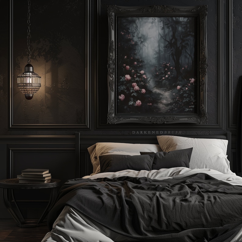May include: A black bedroom with a large framed painting of a foggy forest path with pink flowers. The bed has black bedding and white pillows. A small table with books sits next to the bed.
