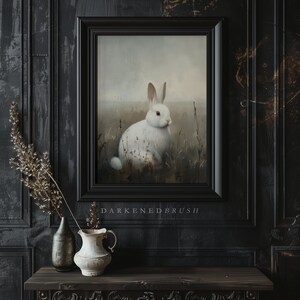 May include: A framed painting of a white rabbit sitting in a field of tall grass. The rabbit has pink eyes and a white nose. The background is a soft, muted gray.
