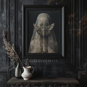 May include: A framed painting of a woman's face partially obscured by a white veil with a large moth resting on it. The painting is set against a dark background and the text "DARKENED BRUSH" is printed below the frame.