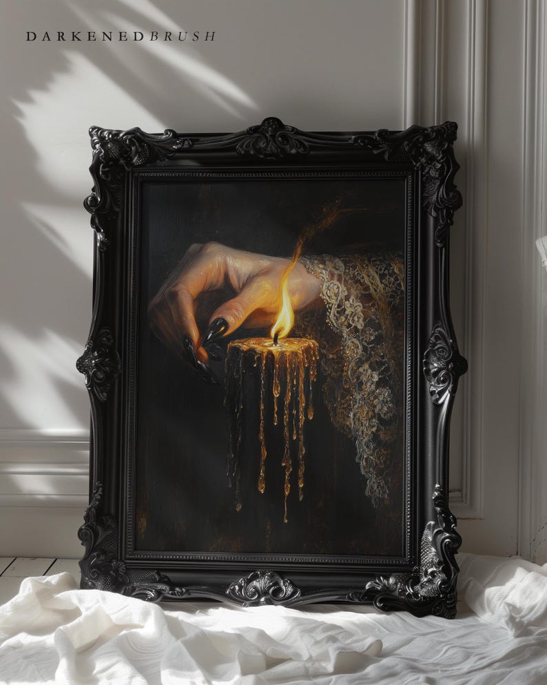 May include: A framed painting with a dark aesthetic. The artwork depicts a hand with long, black nails holding a lit candle with dripping wax. The frame is ornate and black, with the text "DARKENEBRUSH" at the top.