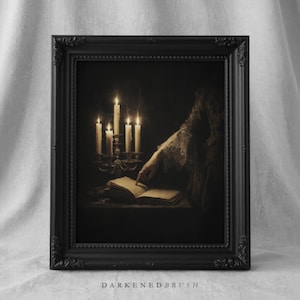 May include: A framed print depicting a gothic scene with a hand pointing to an open book lit by candles. A candelabra with lit candles is visible. The frame is black, and the text "DARKEDBRUSH" is at the bottom.