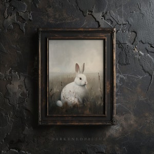 May include: A framed painting of a white rabbit sitting in a field of tall grass. The rabbit is looking to the right, and the background is a soft, blurry landscape.
