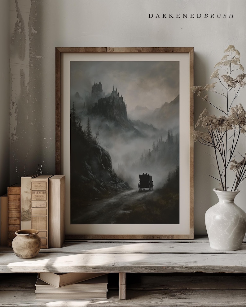 K&ouml;nnte beinhalten: Ein gerahmter Druck eines dunklen, nebligen Landschaftsbildes mit einem Schloss in der Ferne und einer von Pferden gezogenen Kutsche, die auf einer Stra&szlig;e durch den Nebel f&auml;hrt.