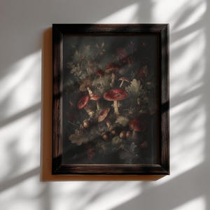 Op de afbeelding: Een ingelijste prent met een gedetailleerde botanische illustratie van paddenstoelen en bladeren in rood, bruin en groen. Het kunstwerk staat tegen een donkere achtergrond en is ingesloten in een donkerbruine houten lijst. De tekst "DARKENEBRUSH" staat bovenaan.
