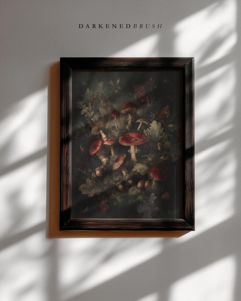 Op de afbeelding: Een ingelijste prent met een gedetailleerde botanische illustratie van paddenstoelen en bladeren in rood, bruin en groen. Het kunstwerk staat tegen een donkere achtergrond en is ingesloten in een donkerbruine houten lijst. De tekst "DARKENEBRUSH" staat bovenaan.