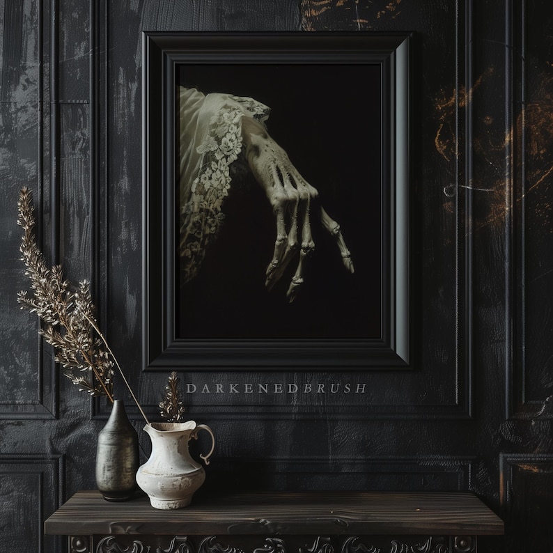 K&ouml;nnte beinhalten: Ein schwarzer gerahmtes Bild mit einer skelettartigen Hand, die eine wei&szlig;e Spitzen&auml;rmel tr&auml;gt. Das Bild h&auml;ngt an einer schwarzen Wand mit dunklem Holzrahmen. Der Text "DARKENED BRUSH" befindet sich unter dem Bild.