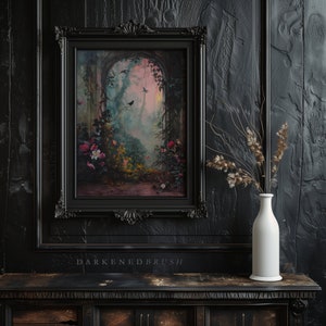 May include: A black framed picture with a painting of a lush, green garden with a stone archway and birds flying through the air. The painting is set against a dark, wood-paneled wall with a white vase and dried flowers.