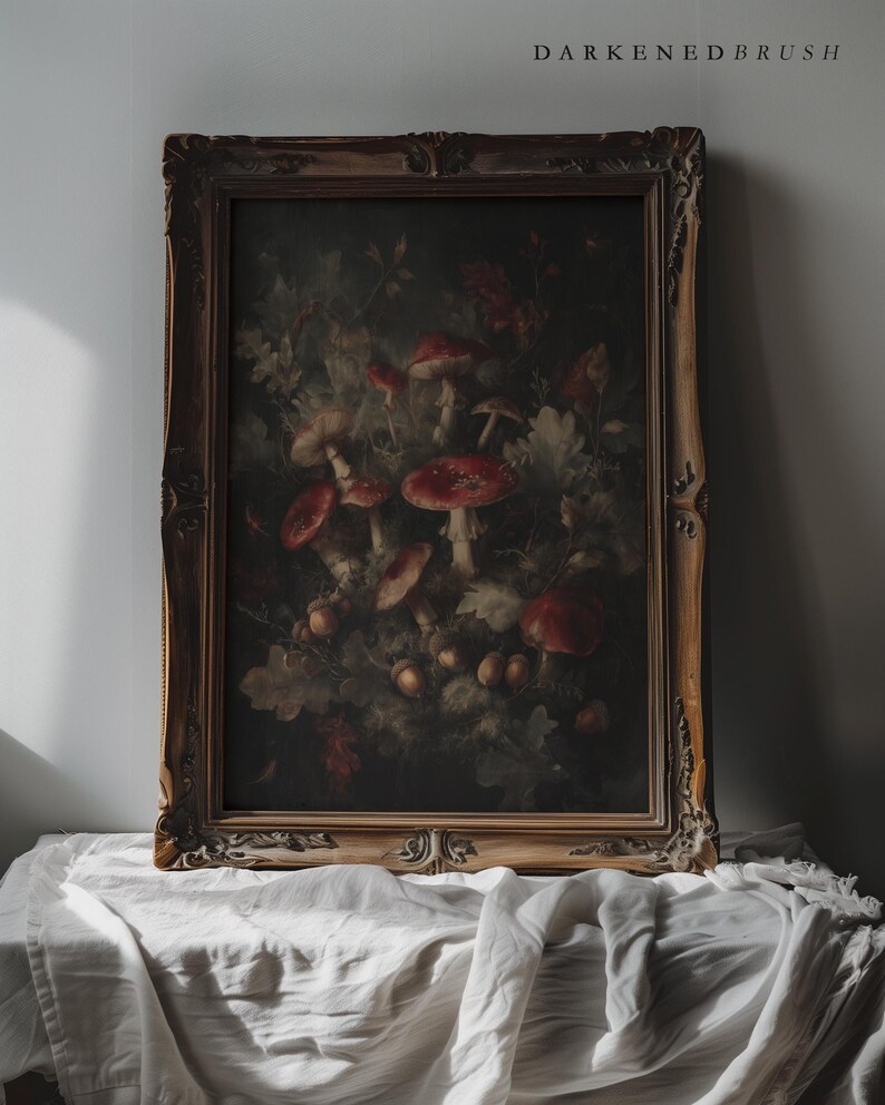 Op de afbeelding: Een ingelijste vintage botanische prent met roodkappige paddenstoelen en bladeren. Het kunstwerk is gevat in een gedetailleerde, sierlijke gouden lijst. De tekst "DARKENDEDBRUSH" staat bovenaan de afbeelding.