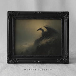 May include: A framed print featuring a dark, gothic-style painting of a dragon perched on a rocky cliff overlooking a misty sea. The dragon is silhouetted against a moody, overcast sky. The frame is black with ornate detailing. The text "DARKENEBRUSH" is at the bottom.
