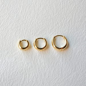 Tapered huggie Hoops Earrings, available in gold and three sizes, perfect for everyday style. Crafted from high-quality material,these earrings embody a harmonious blend of classic sophistication and modern charm