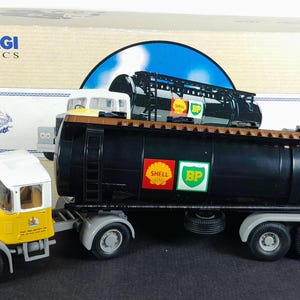 Op de afbeelding: Een Corgi Classics model van een zwarte Shell en BP tankwagen met een gele en witte cabine. Het model heeft gedetailleerde kenmerken, waaronder logo's en realistische wielen. De doos is zichtbaar op de achtergrond.