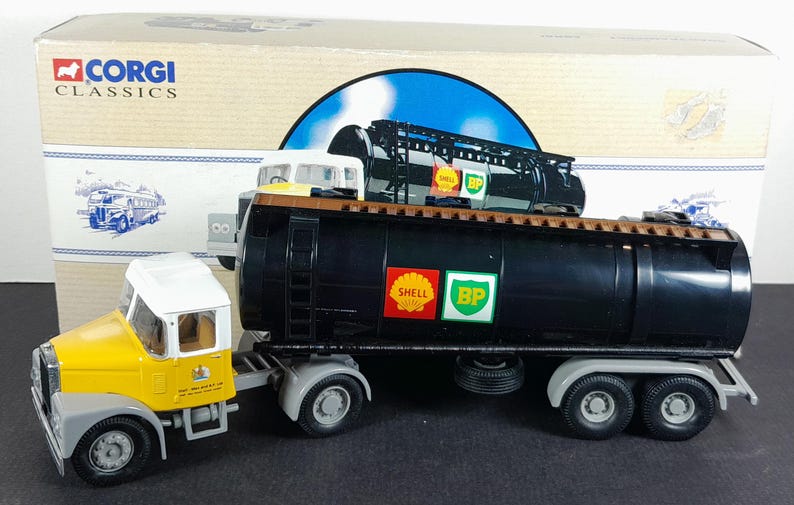 Op de afbeelding: Een Corgi Classics model van een zwarte Shell en BP tankwagen met een gele en witte cabine. Het model heeft gedetailleerde kenmerken, waaronder logo's en realistische wielen. De doos is zichtbaar op de achtergrond.