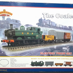 May include: A boxed electric train set, featuring a green steam locomotive with "GWR" lettering and coal wagons. The box is labelled "The Coaler" and "Electric Train Set." The set includes track and is ready to run.