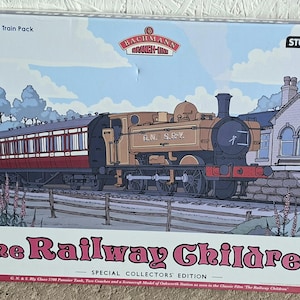 May include: A box depicting a vintage train set, including a locomotive and passenger cars, with the title "The Railway Children." The box is labeled "30-575 OO Scale Train Pack" and features the Bachmann and StudioCanal logos. A special collectors' edition.