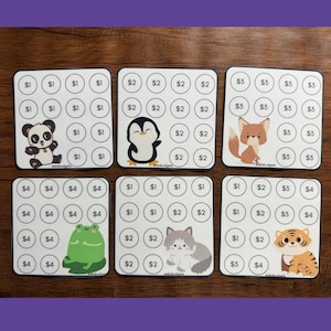May include: Six white square savings tracker cards featuring circular grids with dollar amounts and cartoon illustrations of a panda, penguin, fox, frog, cat, and tiger. Each card displays specific currency values within the circular outlines.