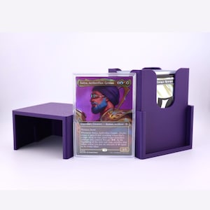 May include: A purple plastic trading card deck box with a matching lid, featuring a clear protective sleeve holding a Satya, Aetherflux Genius card. The card displays a character with a blue beard and goggles, with text detailing game abilities.