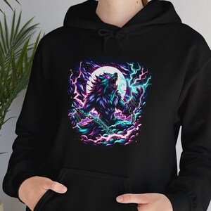 May include: A black hoodie with a graphic print of a werewolf howling at the moon. The werewolf is surrounded by purple and blue lightning bolts and clouds.