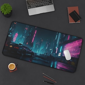 May include: A black and blue gaming mouse pad with a futuristic city scene and a car driving through the streets. The city is lit up with neon lights and the car has a pink glow. The mouse pad is on a black surface.