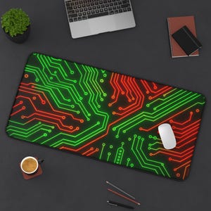 May include: Rectangular mouse pad with a black background and a vibrant circuit board design in neon green and red. A white computer mouse rests on the pad. A laptop, coffee cup, and notebook are also visible.