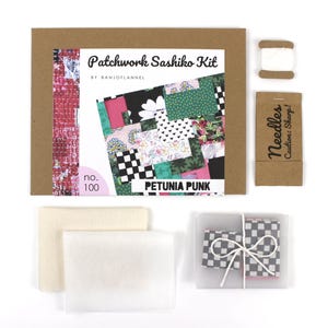 May include: A Patchwork Sashiko Kit by Banjoflannel labeled Petunia Punk no. 100, featuring a brown envelope, white thread on a cardboard spool, a brown paper needle packet, two folded cream fabric squares, and a small box with checkered fabric.