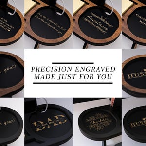 May include: A collection of personalized wooden desk organizers with various engraved messages, including names, phrases like "I love you," and titles such as "Customer Service Manager." The organizers have a black interior and a wooden frame.