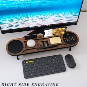 May include: A wooden desk organizer with a phone holder, pen slot, and a round coaster. The organizer has the text "DAD Best Dad Ever" engraved on it. A black keyboard and mouse are in the foreground.