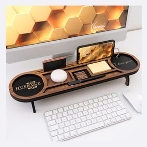 May include: A wooden desk organizer with multiple compartments, including a phone holder, pen slot, and small round trays. The organizer has the words "D♡ HUSBAND ♡D" and "I love you?" on it. A keyboard and mouse are in the foreground.
