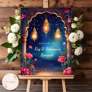 May include: A welcome sign for a Sangeet celebration with a blue and gold archway decorated with floral accents and lanterns. The sign reads "Welcome to Raj & Simran's Sangeet".