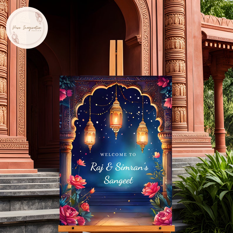 May include: A welcome sign for a Sangeet celebration with a blue background, gold lanterns, and pink flowers. The sign reads "Welcome to Raj & Simran's Sangeet".