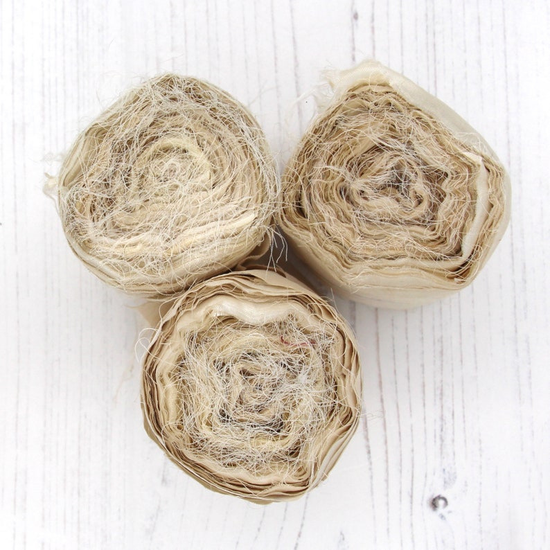 Rolls of undyed recycled sari silk ribbon with raw edges approx 75mm wide and 10m long