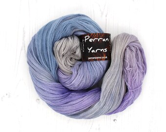 May include: A ball of Perran Yarns luxury yarn in shades of blue, grey, and purple. The yarn is arranged in a circular shape, with a label that reads "Perran Yarns" and the website perranyarns.co.uk.
