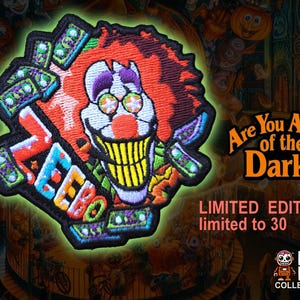 May include: A black and green embroidered patch featuring a clown with a toothy grin, holding a stack of money. The patch says "ZEEBO" and "Are You Afraid of the Dark?"  Limited Edition, limited to 30.