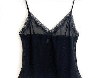 May include: Black lace-trimmed mesh top with a delicate, scalloped hem.