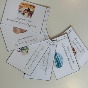 以下が含まれることがあります： 動物と自然に関する質問が書かれたカラフルなカードのセット。カードには、ラクダ、ハリネズミ、鳥、海のイラストが描かれています。