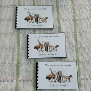 Puede incluir: Tres portadas de libros coloridas con el título "Mis primeros animales" y el texto "Lectura: nivel 1", "Lectura: nivel 2" y "Lectura: nivel 3". Cada portada presenta una ilustración diferente de animales.