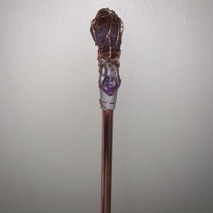 May include: A white ceramic mug with a black handle and the text "But First, Coffee" in a black, bold font. The mug is filled with a dark liquid, likely coffee, and sits on a white surface.