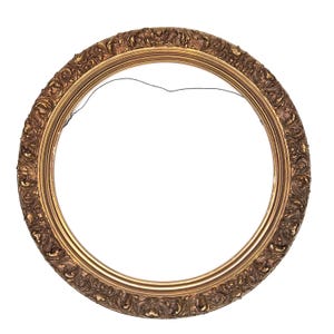 May include: A circular picture frame with a metallic bronze finish and an ornate, raised relief pattern featuring scrolling foliage and floral motifs. The frame has a smooth inner border and a thin black wire attached to the top interior edge.