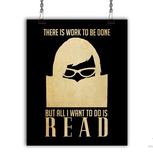 May include: A black and gold poster with the text "THERE IS WORK TO BE DONE BUT ALL I WANT TO DO IS READ". The poster features a silhouette of a person wearing glasses and reading a book.