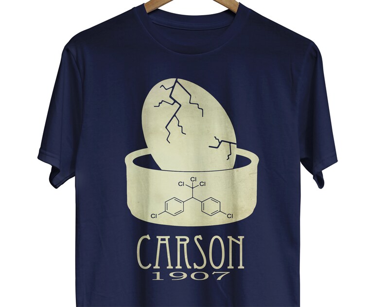 May include: A navy blue t-shirt with a white graphic of a cracked egg with a chemical formula inside. The text "CARSON 1907" is printed below the graphic.