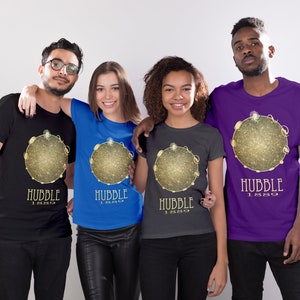 May include: Four people wearing t-shirts with a gold and black graphic of a galaxy with the text "Hubble 1990". The shirts are black, blue, gray, and purple.
