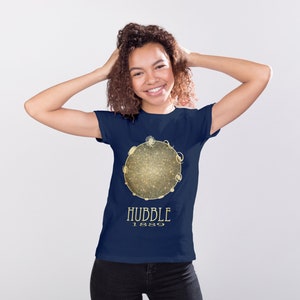 May include: A navy blue t-shirt with a gold graphic of a galaxy and the text "HUBBLE 1989".