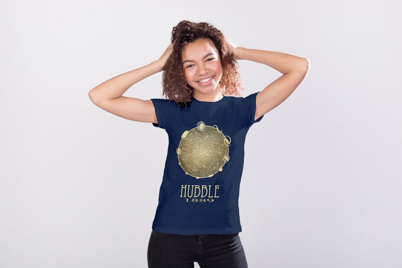 May include: A navy blue t-shirt with a gold graphic of a galaxy and the text "HUBBLE 1989".