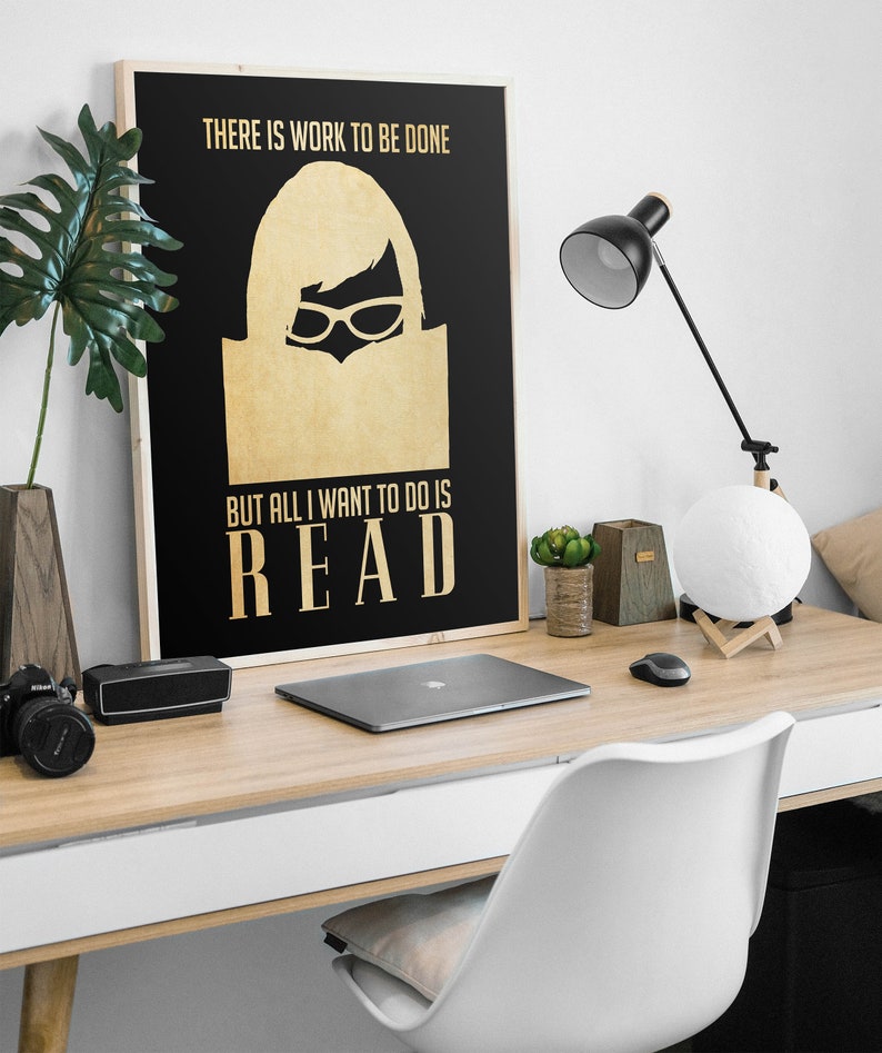 May include: A black and gold poster with the text "There is work to be done, but all I want to do is READ". A silhouette of a woman wearing glasses and reading a book is in the center of the poster.