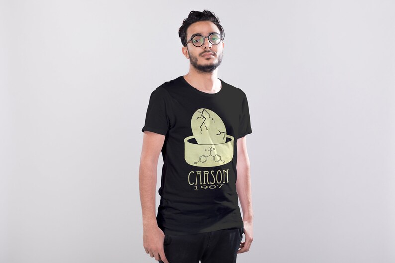 May include: A black t-shirt with a graphic of a cracked egg in a bowl with a chemical formula and the text "CARSON 1907".