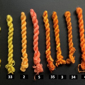 May include: A collection of eight twisted embroidery floss skeins in a gradient of yellow, orange, and coral hues. Each skein is labeled with a number from 1 to 35, showcasing a range of colors for crafting projects.