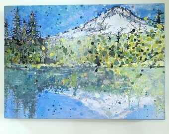May include: A rectangular painting featuring a snow-capped mountain peak, dark evergreen trees, and a reflective lake. The artwork uses a mixed media style with blue, green, yellow, and white paint splatters layered over a detailed landscape scene.
