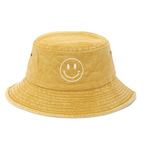 May include: A yellow bucket hat with a white smiley face embroidered on the front.