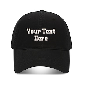 Op de afbeelding: Zwarte baseballpet met een gebogen klep. De pet heeft de tekst "Your Text Here" in witte blokletters. De pet is gemaakt van een zacht materiaal en heeft een klassieke, casual stijl.