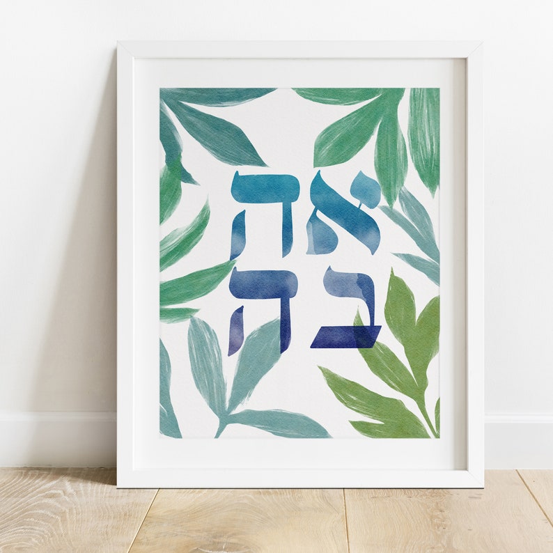 Framed example of a digital art print with the Hebrew word for "love" in  blue watercolor surrounded by painted leaves in shades of green.